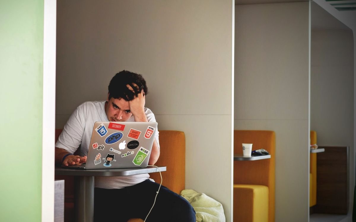 Hombre pensativo con laptop, evaluando un cambio en su vida laboral